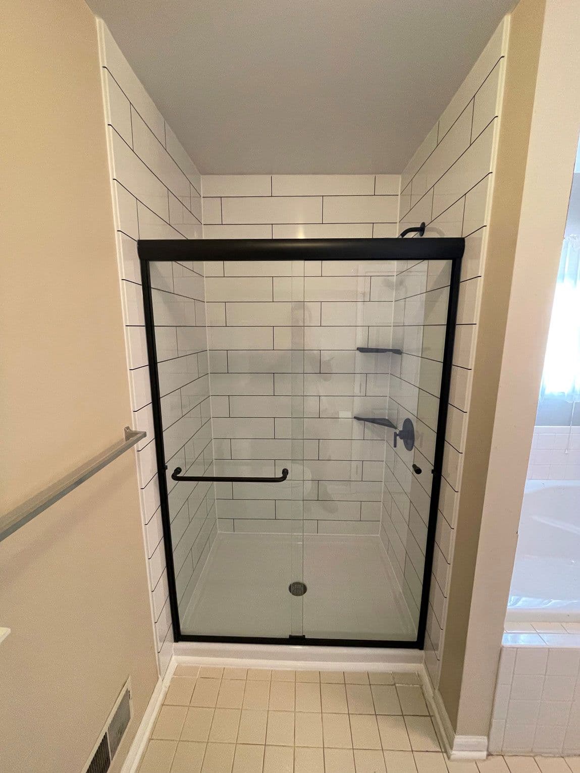 White-tiles-black-door-frame-remodeled-shower-bathroom-pros